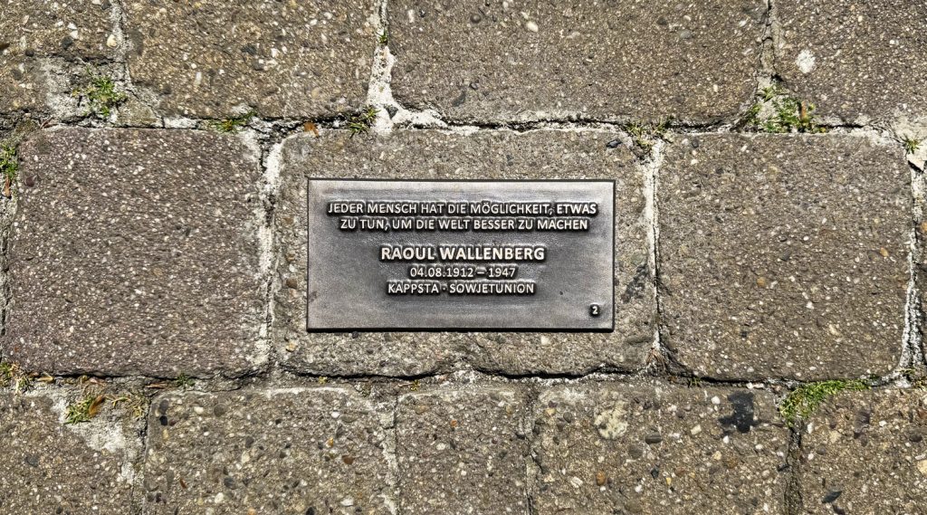 Bodenplatte zur Erinnerung an Raoul Wallenberg mit Lebensdaten und dem Zitat „Jeder Mensch hat die Möglichkeit, etwas zu tun, um die Welt besser zu machen“.