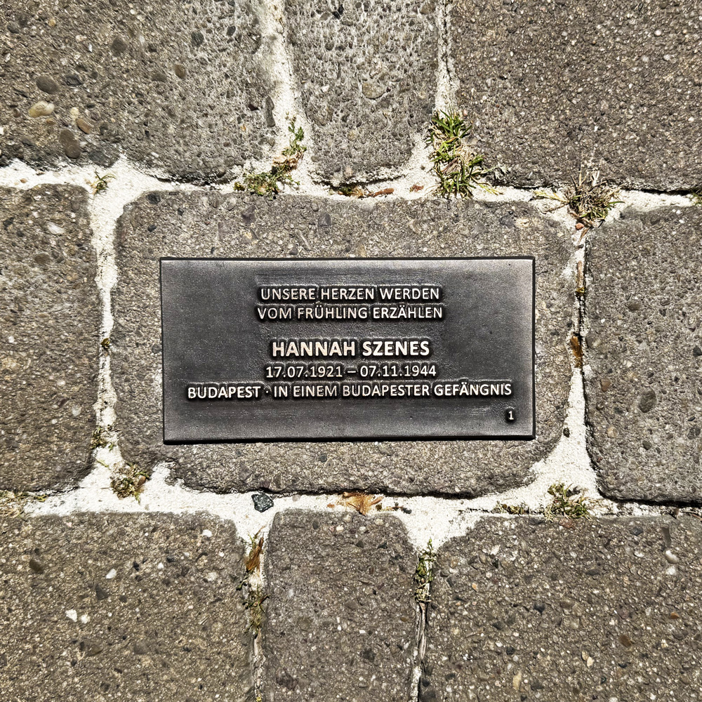 Bodenplatte für Hannah Szenes mit Lebensdaten, Herkunft und dem Zitat „Unsere Herzen werden vom Frühling erzählen“.