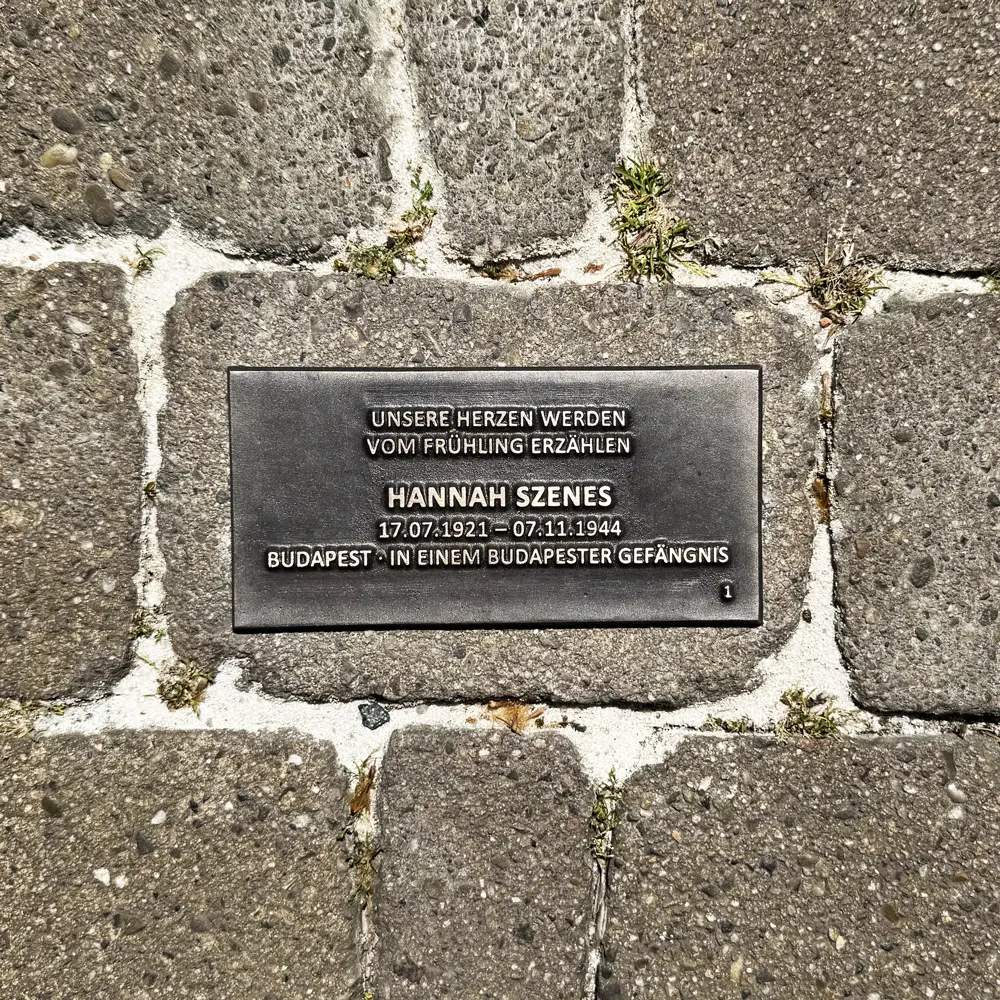Bodenplatte für Hannah Szenes mit Lebensdaten, Herkunft und dem Zitat „Unsere Herzen werden vom Frühling erzählen“.