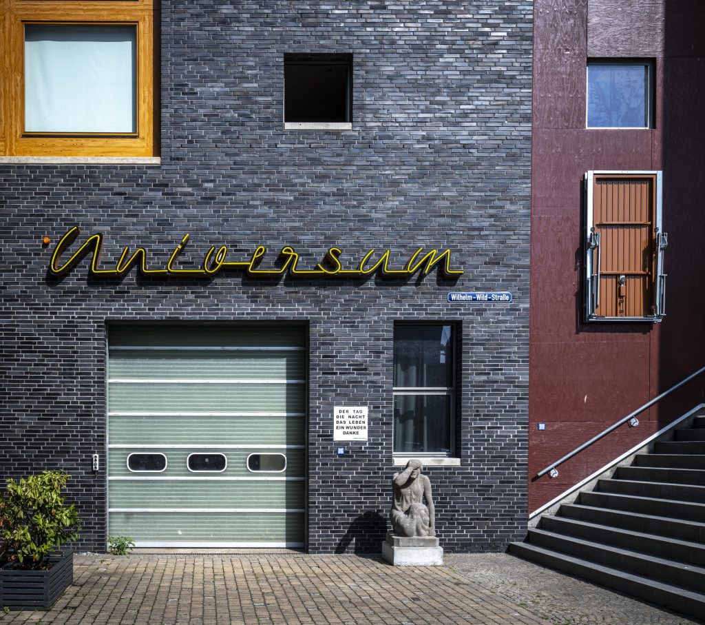 Schriftzug „Universum“ über Garagentor und Statue an der Wilhelm-Wild-Straße.