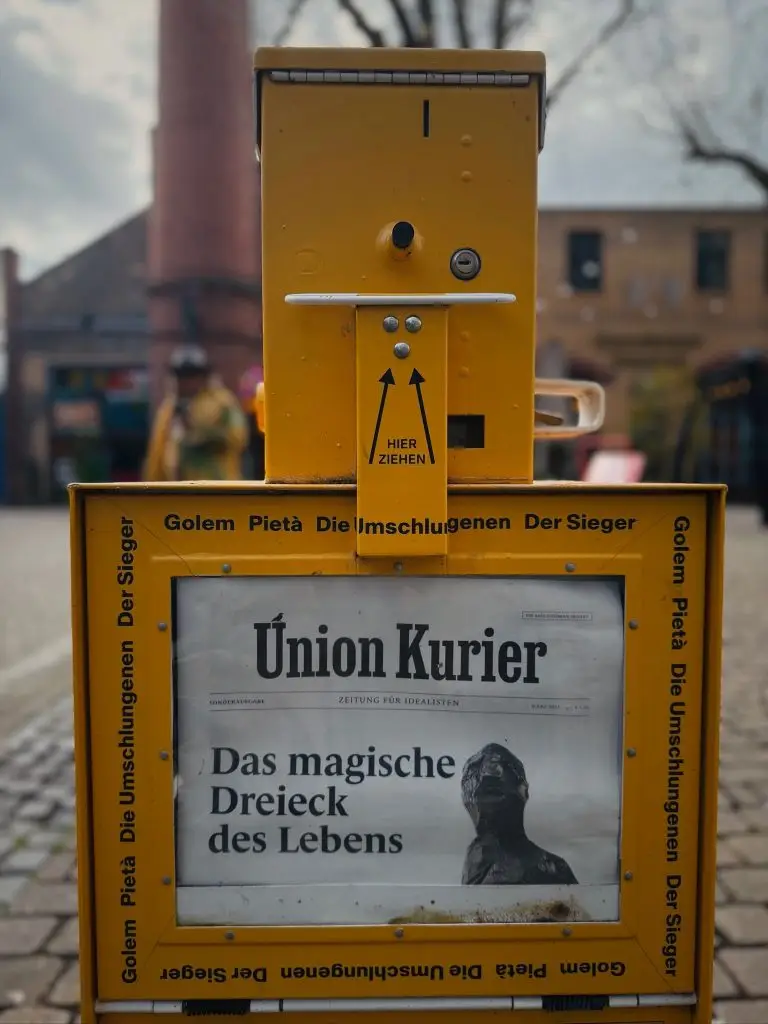 Gelber Zeitungsautomat für den "Union Kurier" auf dem Union-Gelände Frankfurt, Titel: "Das magische Dreieck des Lebens".