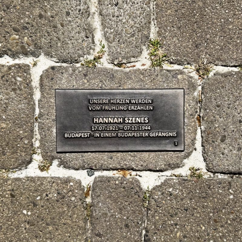 Bodenplatte für Hannah Szenes mit Lebensdaten, Herkunft und dem Zitat „Unsere Herzen werden vom Frühling erzählen“.