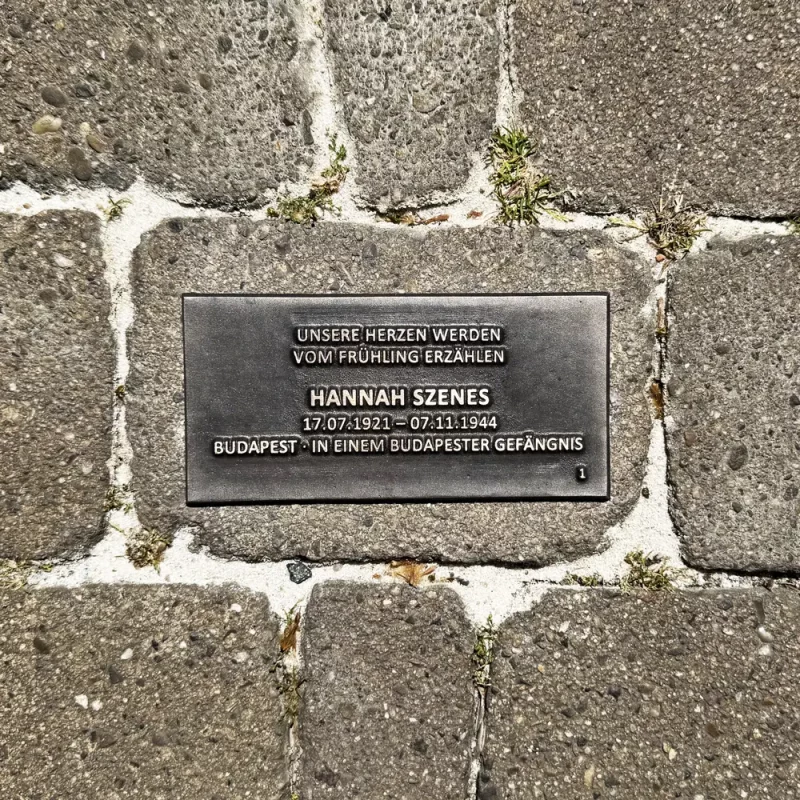 Bodenplatte für Hannah Szenes mit Lebensdaten, Herkunft und dem Zitat „Unsere Herzen werden vom Frühling erzählen“.