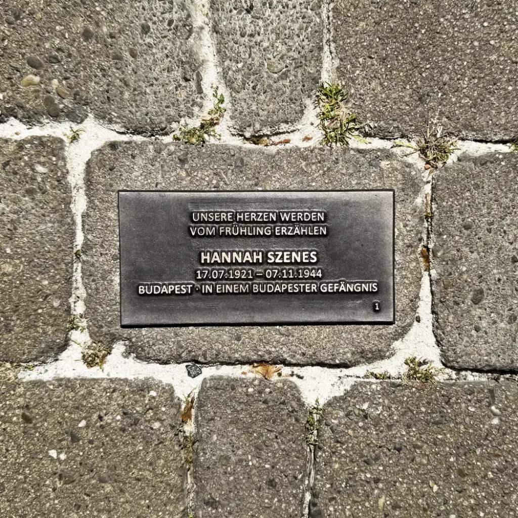 Bodenplatte für Hannah Szenes mit Lebensdaten, Herkunft und dem Zitat „Unsere Herzen werden vom Frühling erzählen“.
